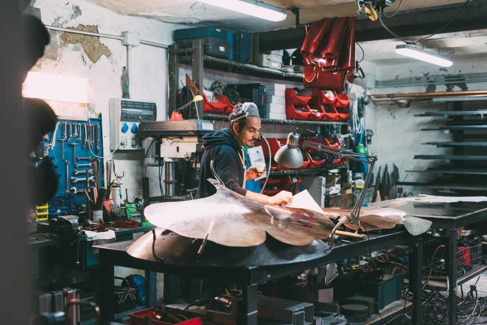 Metalworker looking at design blueprint for copper in forge workshop